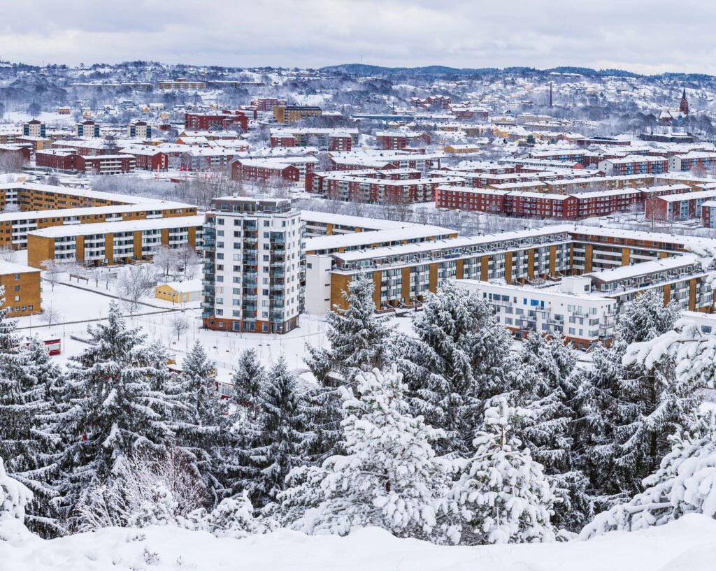 Hochwinkelaufnahme eines schneebedeckten Wohngebiets/Firmengeländes.