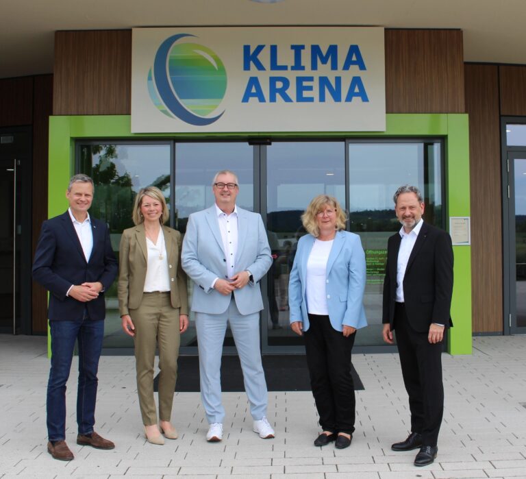 Fünf Personen stehen vor dem Gebäude der KLIMAARENA in Sinsheim